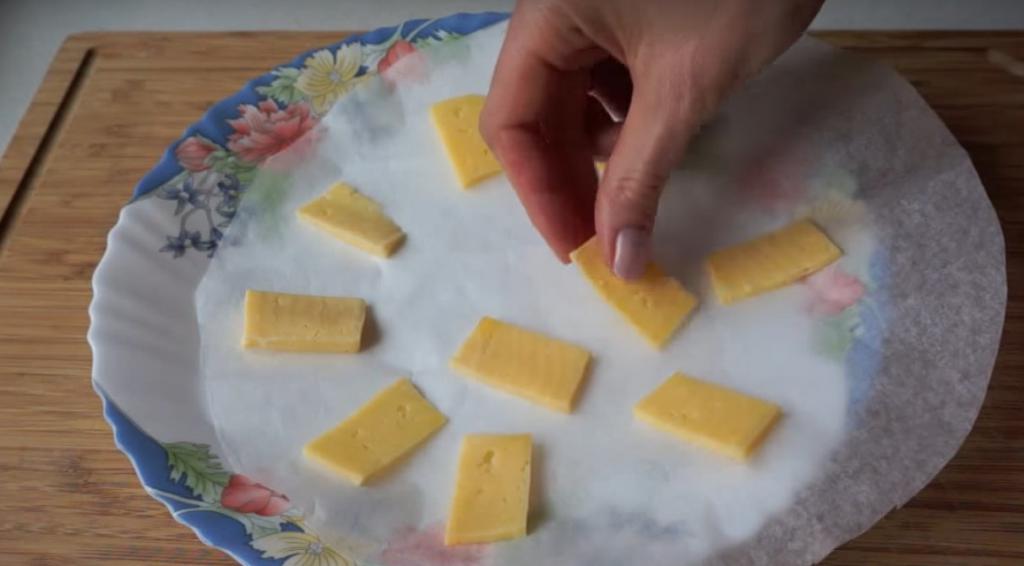 раскладывание ломтиков сыра на тарелку