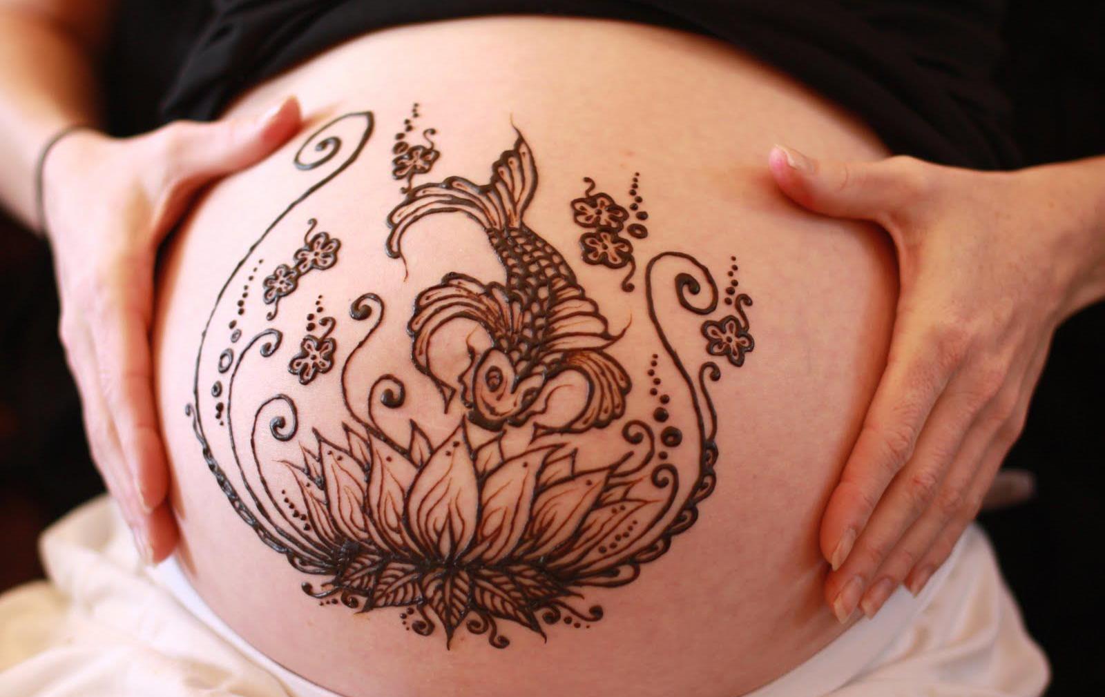 Тату хной цветок лотоса и карп на животе беременной девушки
