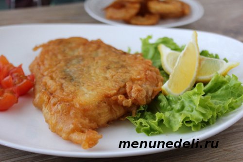 Приготовленная рыба в кляре с салатом и лимоном на ужин или обед