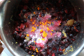 В кастрюльку выкладываем ягоды сахар апельсиновый сок цедру 