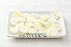 Отварите яйца (варить 2-3 минуты с момента закипания) и нарежьте половинками.