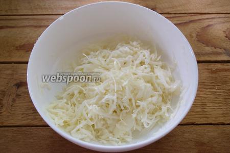 Капусту белокочанную нарезать очень мелко и тонко. Добавить соль и щипку сахара. Помять руками.