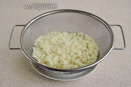 Рис тщательно промыть в нескольких водах до полного исчезновения мути. Бульонный кубик растворить в 0,5 л воды, довести до кипения, выложить в него рис и отварить его до мягкости, а затем выложить на дуршлаг и остудить.