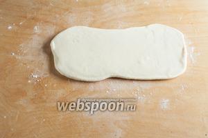 На обсыпанной мукой рабочей поверхности тесто раскатывается в вытянутый прямоугольник толщиной 1 см.